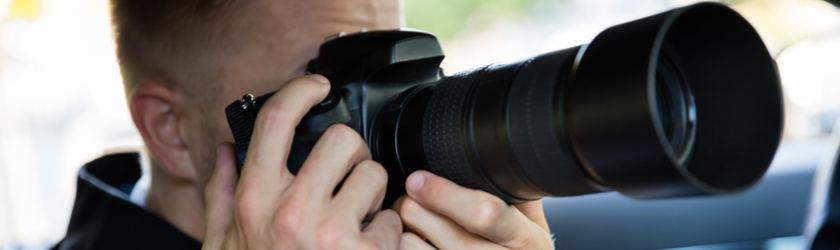 Man takes a photo using a camera with a zoom lens